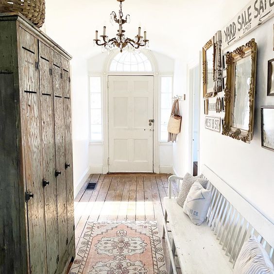 Tour this charming old home with an entry filled with antique finds like this chippy green cabinet and white bench #foyer #entry #farmhousedecor #farmhousefoyer #vintagedecor #vintage #antiques #gallerywall #fixerupperstyle 