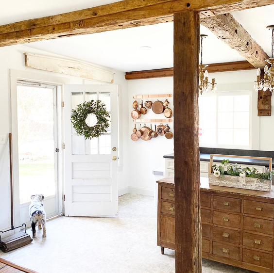 Tour this charming farmhouse with original wood beams on the ceiling and an old apothecary as a kitchen island #kitchen #farmhousedecor #farmhousekitchen #fixerupperstyle #vintagedecor #apothecary #woodbeams #interiordecor #interiordesign #cottagestyle #antiques