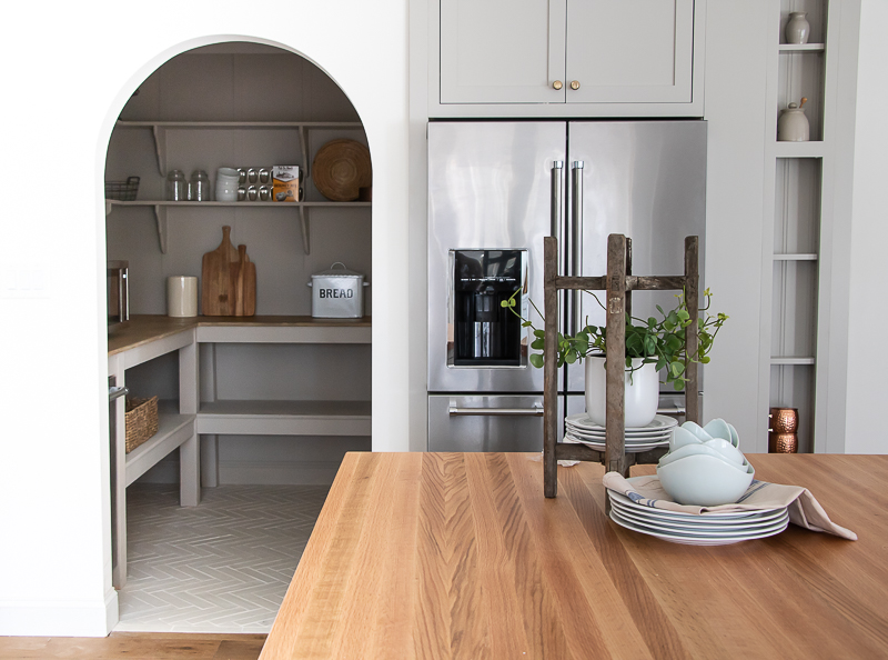 Love the arched doorway from this farmhouse kitchen into the pantry #pantry #kitchen #farmhousekitchen #butlerspantry #butcherblockcounter ##farmhousedecor #graykitchen