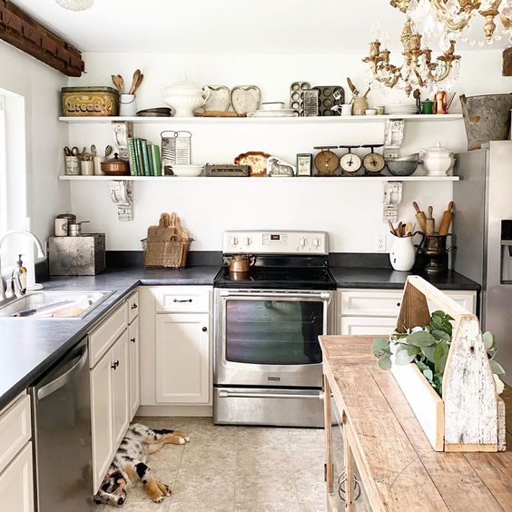 Charming farmhouse kitchen with open shelves held up by antique corbels #kitchen #farmhousekitchen #farmhousedecor #kitchendecor #vintagedecor #openshelves #shelfie #shelfstyling #kitchenisland 