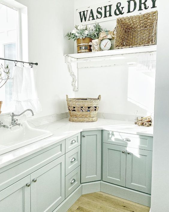 Farmhouse laundry room with light blue cabinets and marble counters kellyelko.com #laundryroom #laundryroomdecor #bluecabinets #farmhouse #farmhousedecor #farmhouselaundry #vintagedecor 