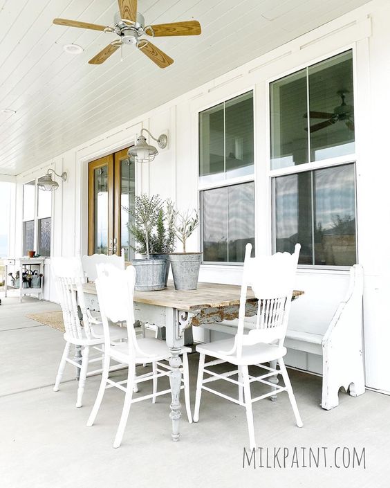 Beautiful farmhouse porch with milk paint vintage table and chairs kellyelko.com #farmhouse #farmhousefurniture #farmhouseporch #farmhousedecor #vintagedecor #vintagefurniture #porch #porchdecor #churchpew #paintedfurniture #diyideas