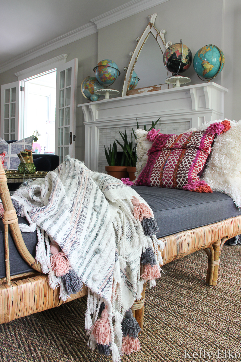 Love this eclectic boho living room with rattan daybed and vintage globe collection on the mantel kellyelko.com #eclecticdecor #livingroomdecor #manteldecor #vintagemodern #vintagedecor #rattan #rattanfurniture #daybed #collections #collect #manteldecor #mantel #interiordesign #cozydecor #globes #kellyelko #article