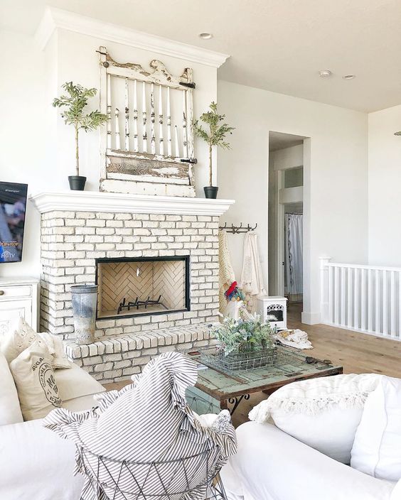 Love this antique architectural find on the mantel in this farmhouse kellyelko.com #mantel #farmhousemantel #manteldecor #farmhouse #farmhousedecor #farmhousemantel #upcycle #repurpose #architecturalelement #brickfireplace #whitebrick #farmhousefamilyroom #fixerupper