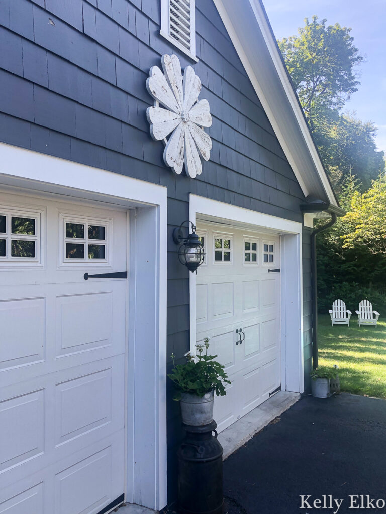 Love this huge barn wood flower hung on the outside of her house kellyelko.com #farmhousedecor #farmhousestyle #outdoordecor #garage #halenavy #bluepaint #exteriorpaint #housepaint #garage