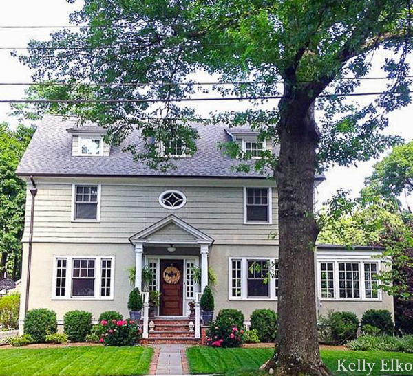 Old house curb appeal with green paint and a welcoming front porch kellyelko.com #oldhome #oldhouse #housepaint #greenhouse #frontporch #curbappeal #landscaping #gardening #gardens 