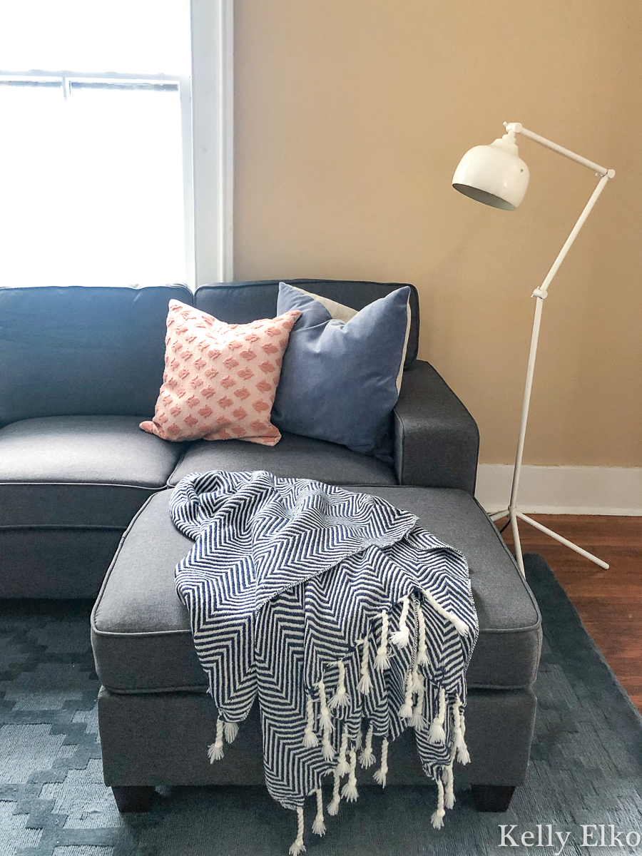 Beautiful sofa with cozy throw and pillows kellyelko.com #cozydecor #throwblanket #floorlamp #sectionalsofa #collegedecor #apartmentdecor 