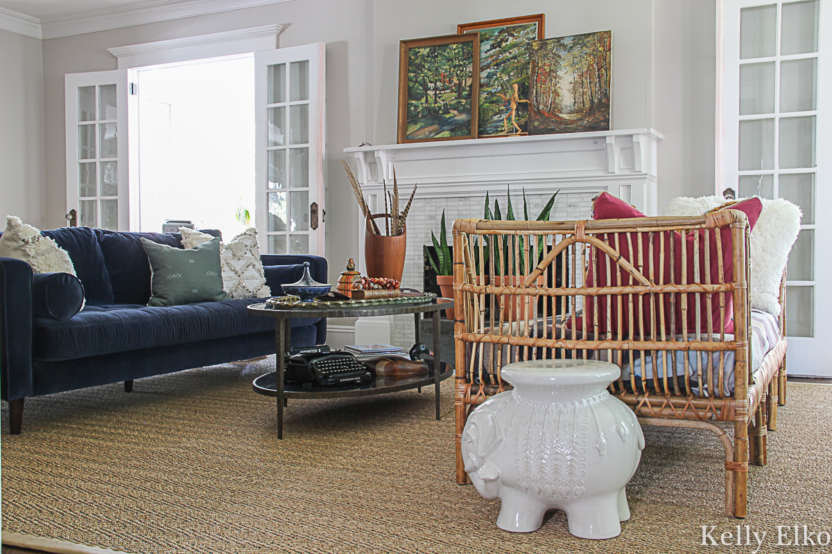 Eclectic living room with vintage landscapes and boho rattan daybed kellyelko.com #eclecticdecor #vintagedecor #landscapes #paintings #vintagelandscape #falldecor #manteldecor #modernvintage #livingroomdecor #livingroomfurniture #article