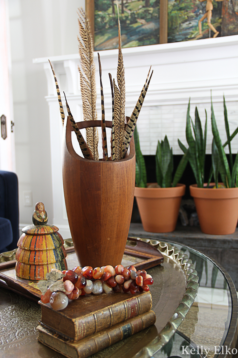 Love these feathers displayed in a vintage teak ice bucket - so many beautiful fall decorating ideas kellyelko.com #fall #falldecor #vintagedecor #vintage #fallhometour #feathers #eclecticdecor #collections 