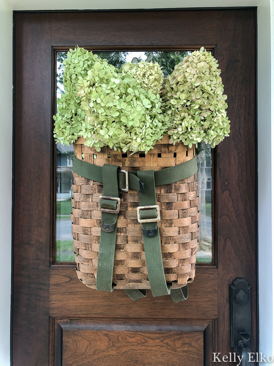 Love this vintage Adirondack basket used as a door wreath kellyelko.com #basket #basketwreath #wreath #wreaths #fallwreath #summerwreath #curbappeal #diywreath #hydrangeas #limelight #vintagedecor #eclecticdecor #frontdoor