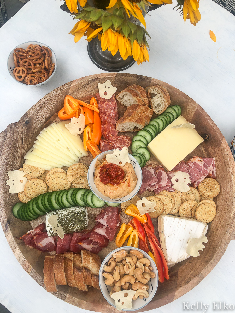 This fall charcuterie board is huge! I love the little ghost shaped crackers kellyelko.com #charcuterie #charcuterieboard #cheeseplatter #cheeseboard #meatandcheese #appetizers #partyfood #boards #fallfood #fallparty #fallcharcuterie #partyfood 