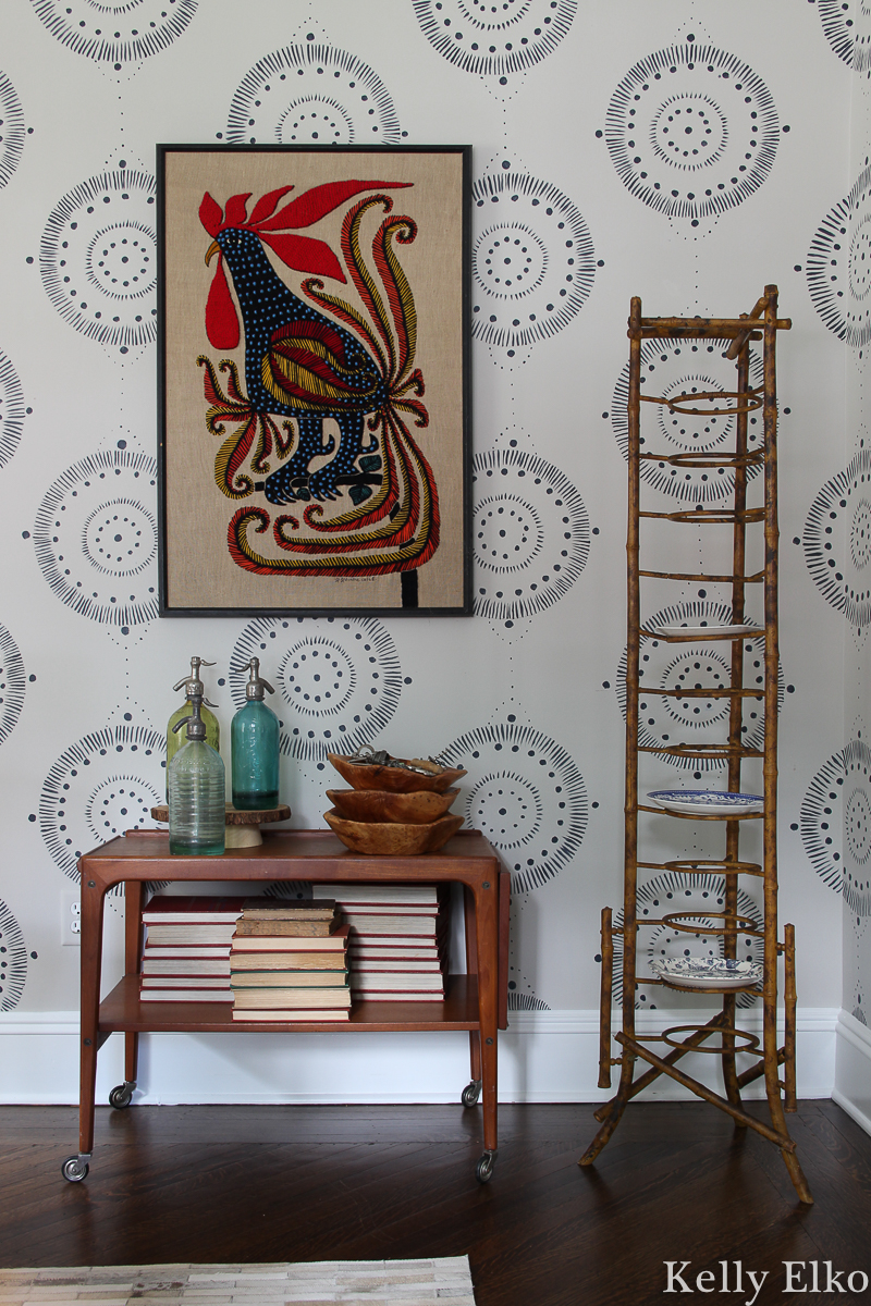 Love this eclectic mix of vintage pieces including a Danish modern bar cart, antique bamboo plate rack and unique crewel rooster art kellyelko.com #vintage #vintagedecor #antique #antiquedecor #eclecticdecor #danishmodern #bamboo #diningroomdecor #crewelwork #vintageart #vintagebamboo 