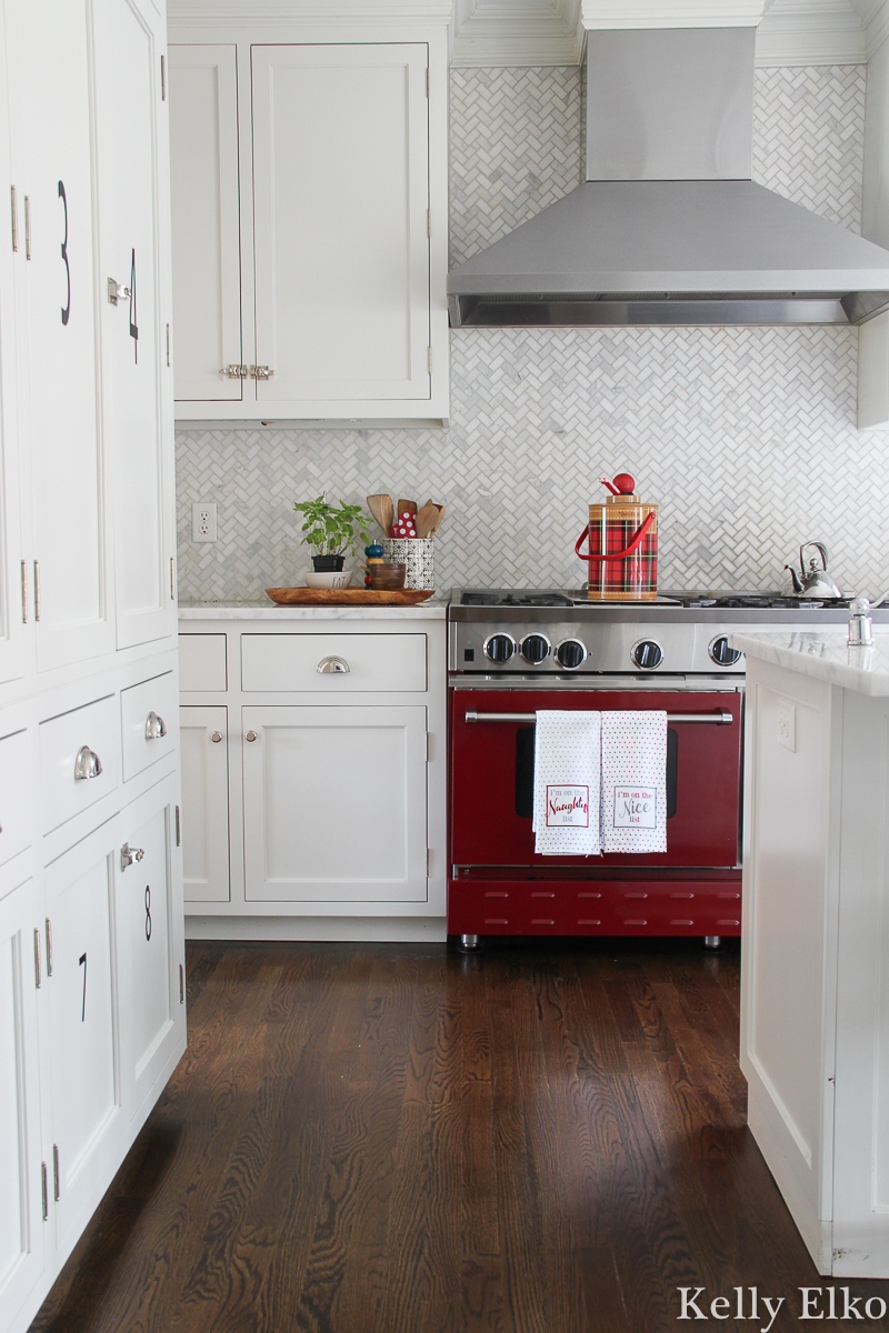 Beautiful red stove is the perfect pop of color in this classic white kitchen kellyelko.com #whitekitchen #redstove #christmaskitchen #vintagechristmas #carraramarble