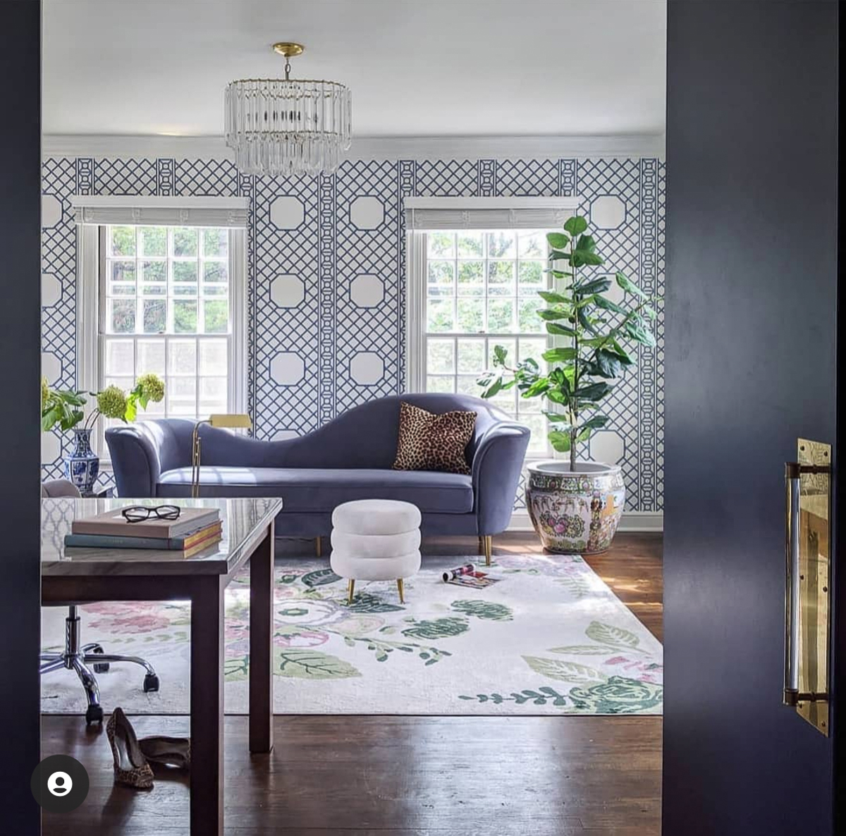 Serene home office sunroom with trellis wallpaper and blue sofa