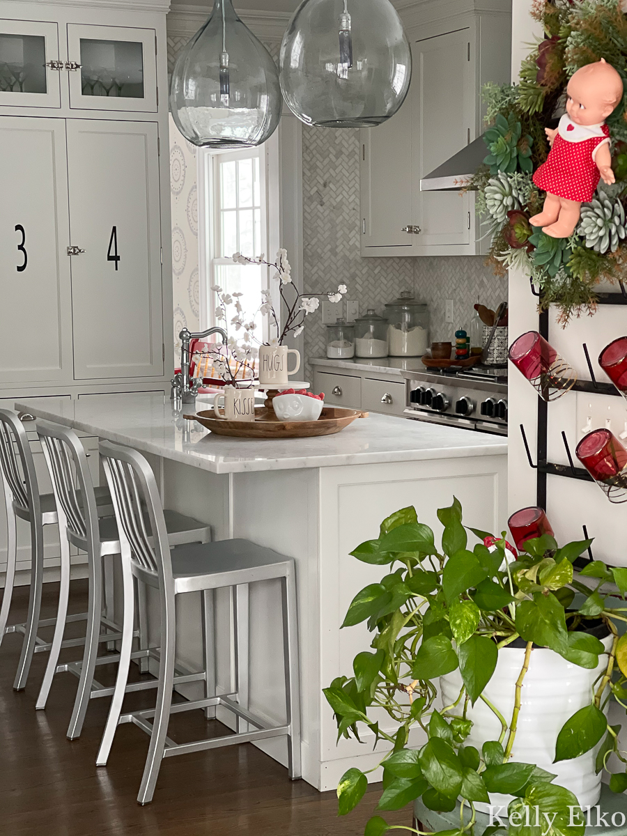 Love this white kitchen with simple Valentine decor including an adorable Kewpie doll wreath kellyelko.com 