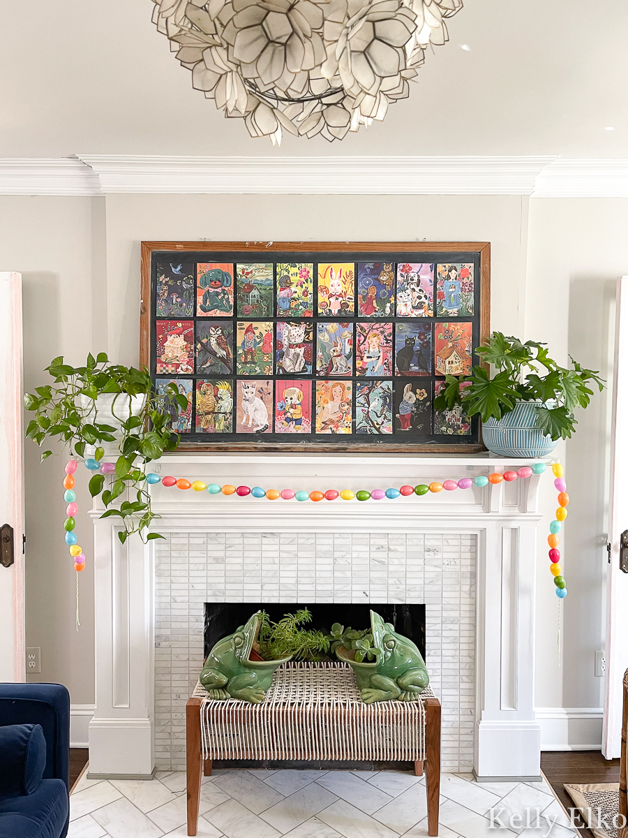 Love this colorful spring mantel with oversized art and a fun diy egg garland for Easter kellyelko.com