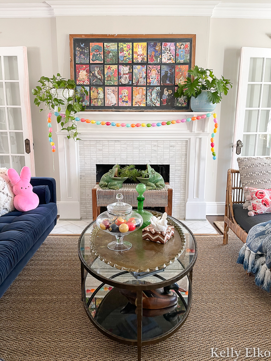 Love this spring mantel with oversized art collage, DIY egg garland and plants kellyelko.com