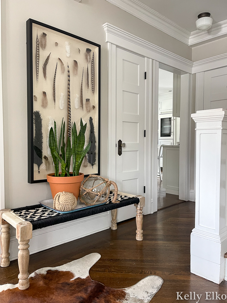 Beautiful foyer with feather art and a woven bench kellyelko.com