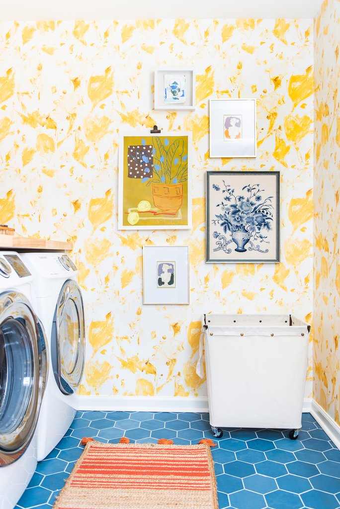 Love this stunning yellow floral wallpaper paired with vibrant blue tile floor in this fun laundry room kellyelko.com