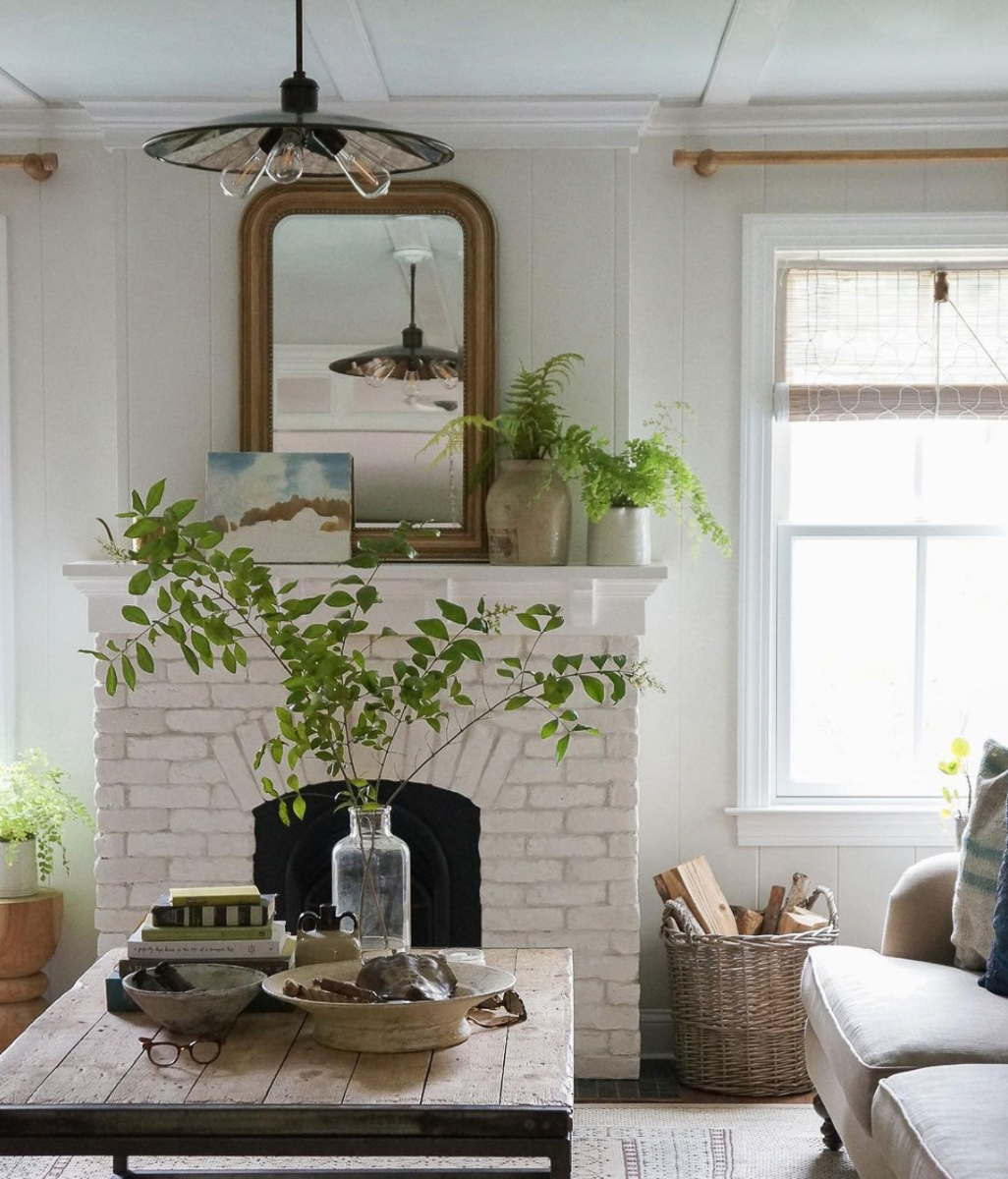 Painted brick fireplace in this stunning farmhouse filled with plants and vintage finds kellyelko.com