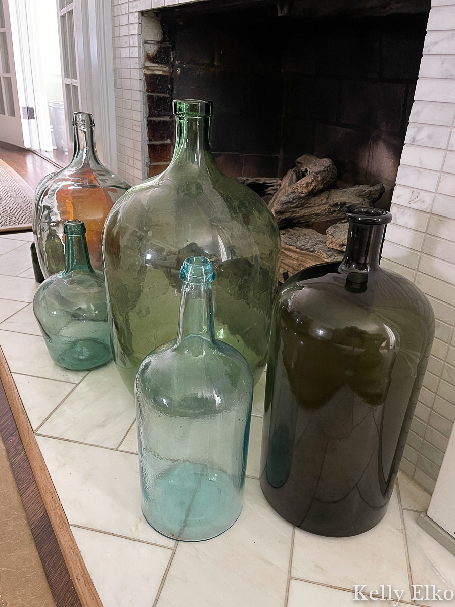 Gorgeous collection of antique demijohn wine bottles on the hearth kellyelko.com