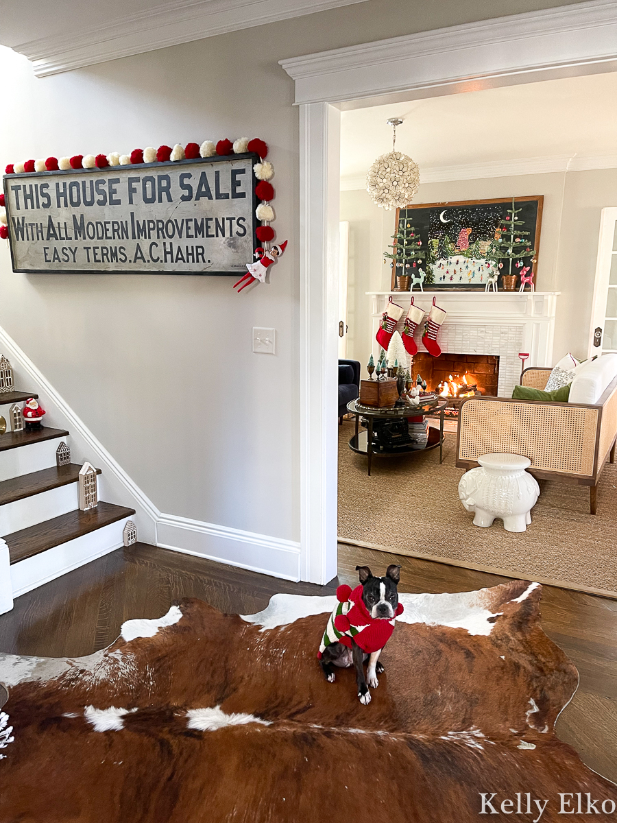 Love this vintage filled Christmas home tour kellyelko.com - the antique wood sign with pom pom garland 