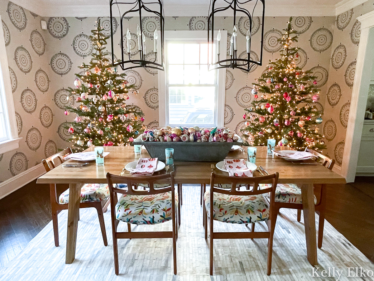 Pair of sparse Christmas trees in the dining room covered in vintage ornaments kellyelko.com