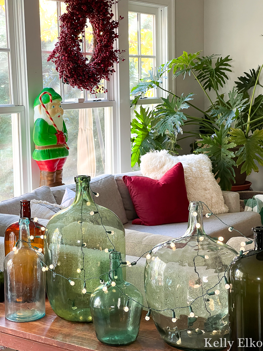 Love this festive home tour - the antique glass jars filled with string lights and the festive vintage elf blow mold kellyelko.com