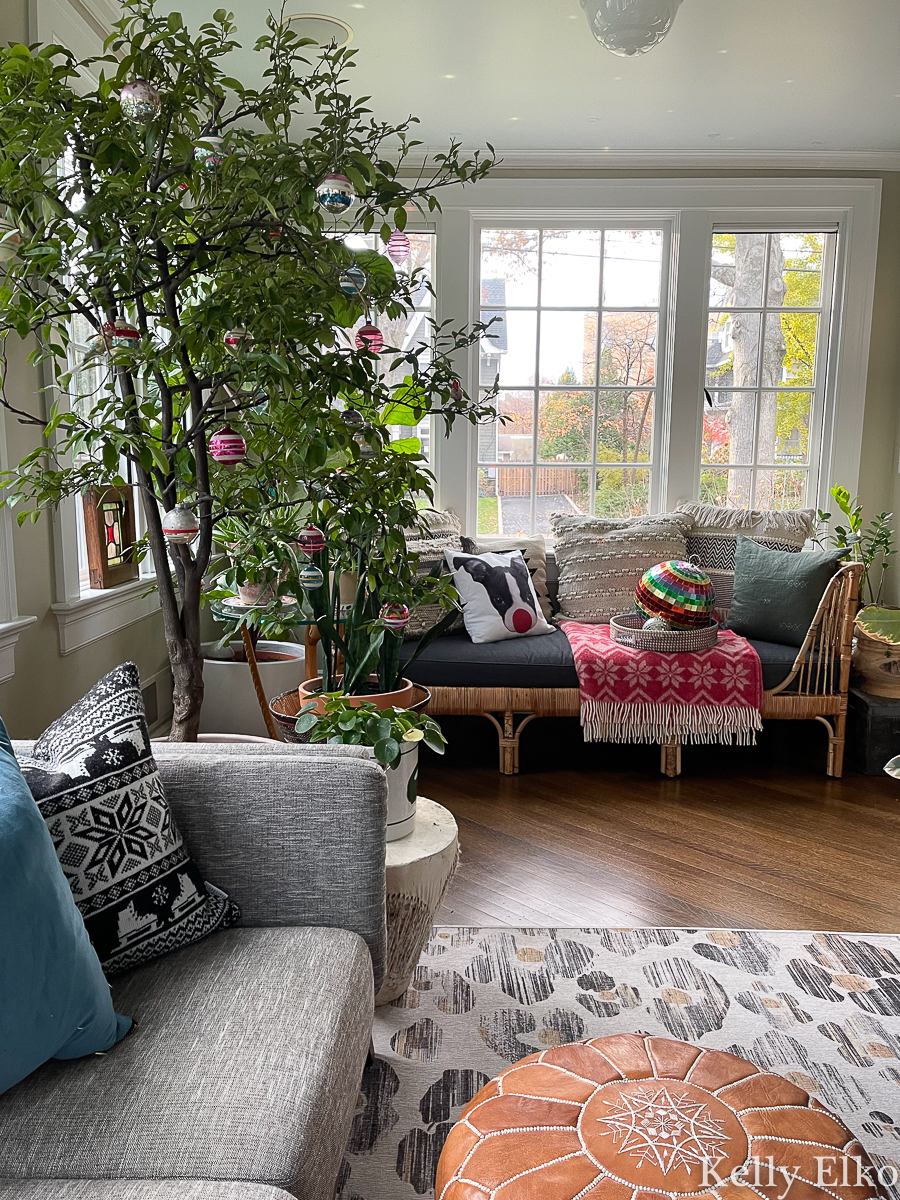 Festive Christmas sunroom - love the tree with vintage Shiny Brite ornaments and the rattan daybed kellyelko.com