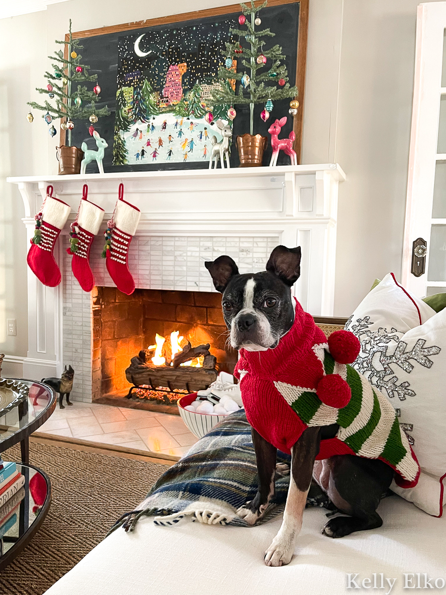 Love this whimsical Christmas mantel with vintage art and shiny brite ornaments plus the adorable Boston Terrier in a cute sweater kellyelko.com