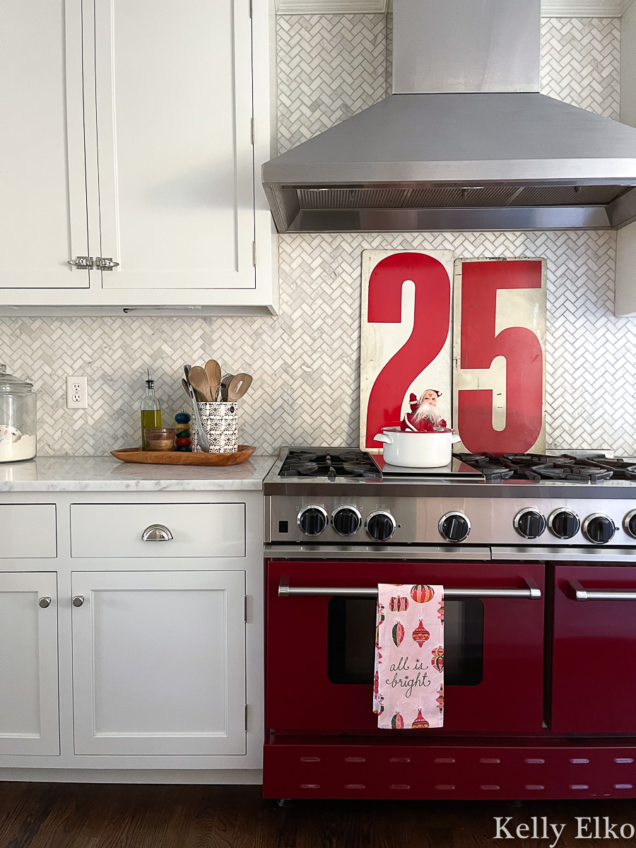 Love the huge vintage 25 numbers for Christmas in this farmhouse kitchen - and love the red stove! kellyelko.com