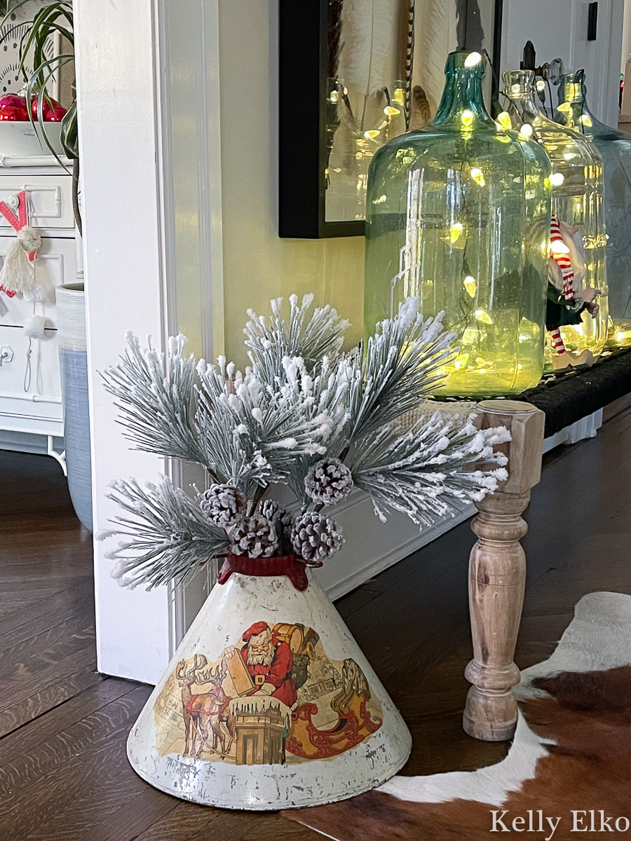 Love this vintage Christmas tree stand with Santa graphics used as a vase for branches kellyelko.com