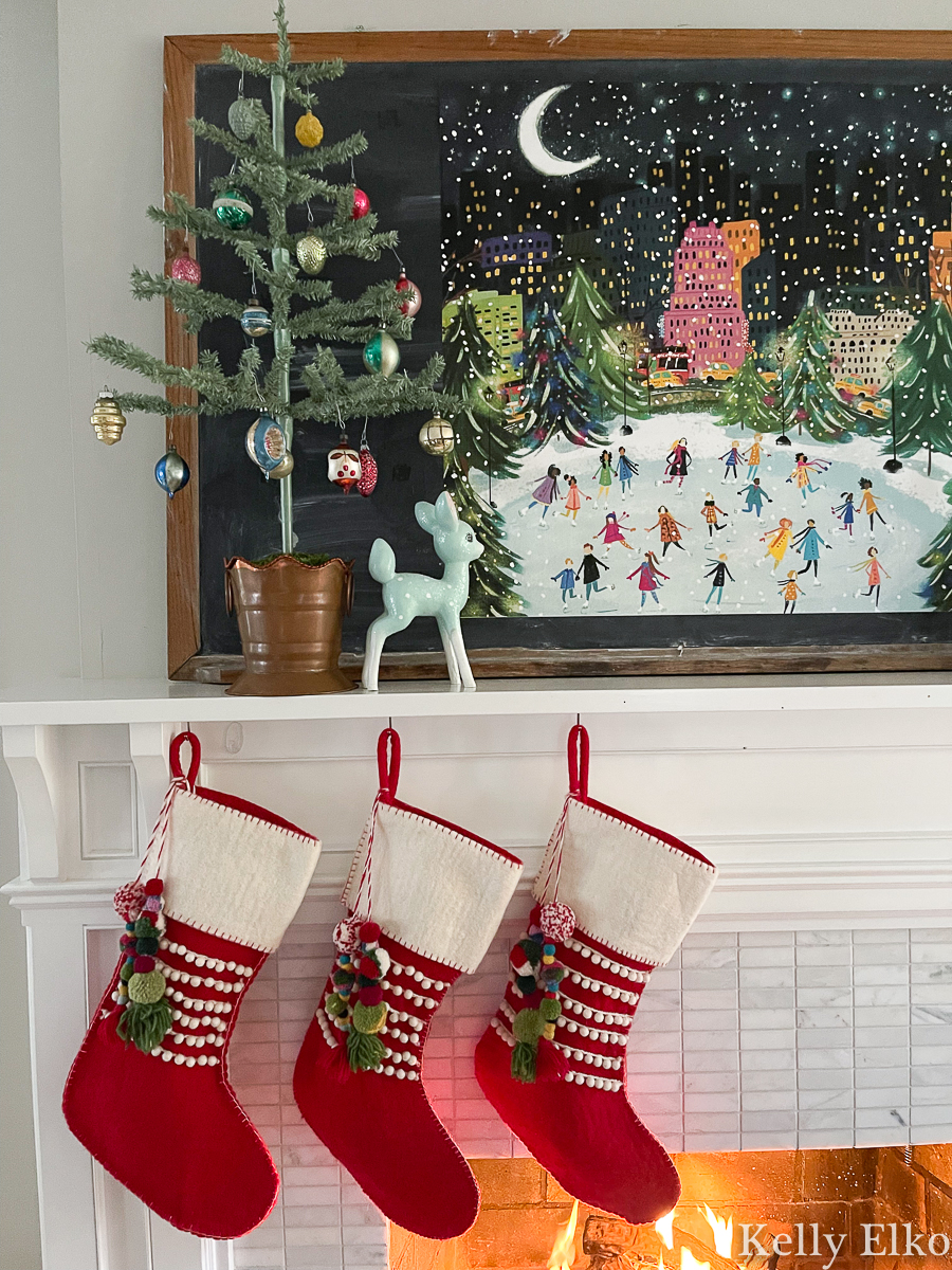 Whimsical Christmas mantel with ice skaters in NYC art and pom pom stockings kellyelko.com
