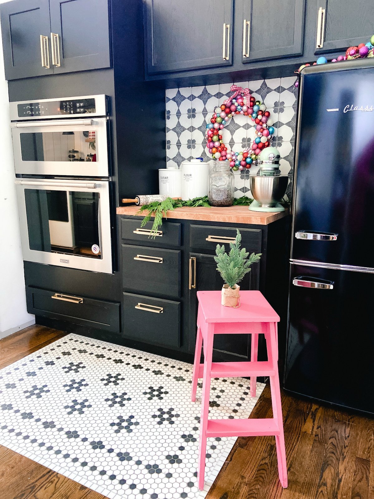 Black kitchen cabinets and black and white backsplash is stunning