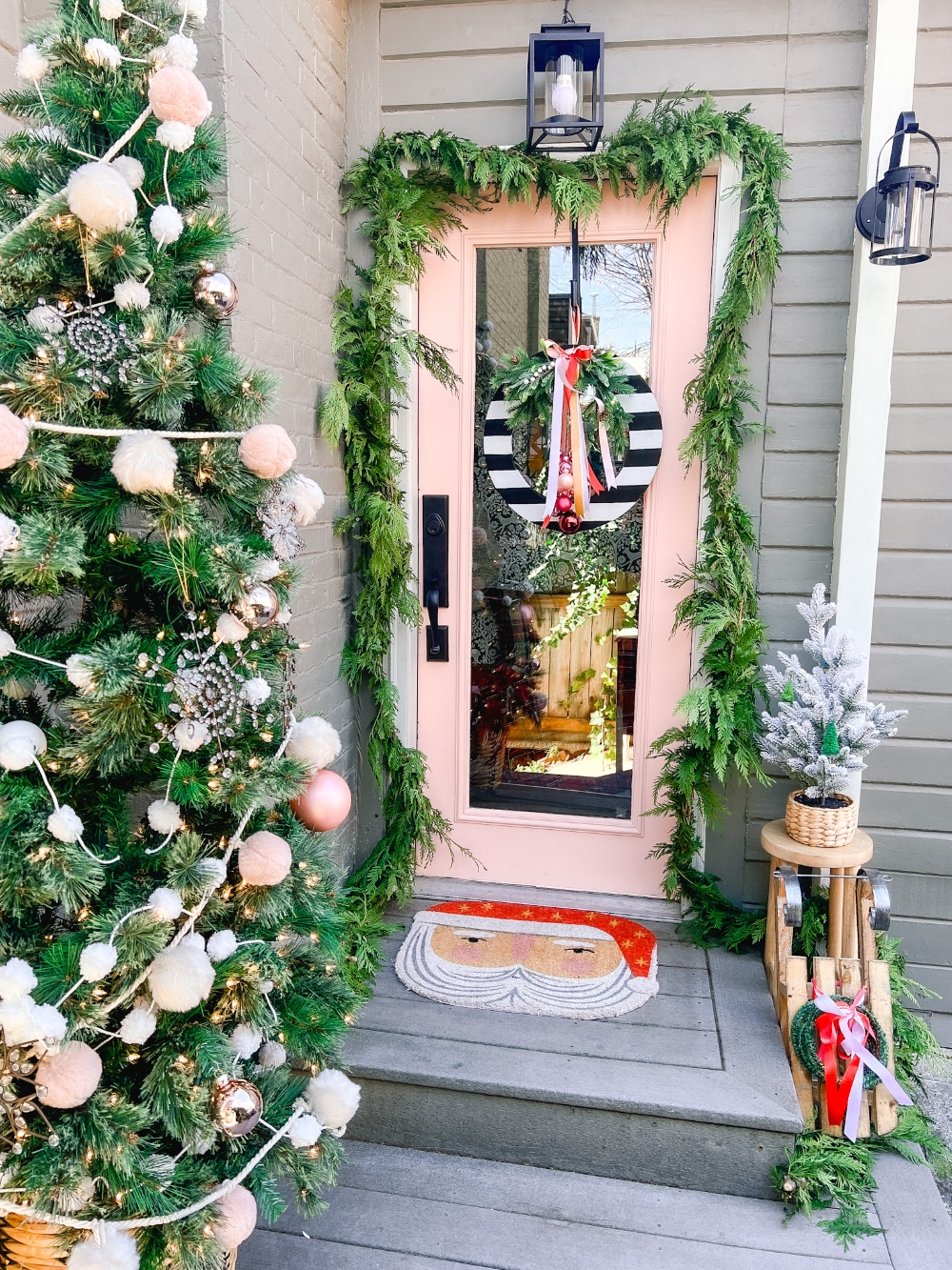 Back porch gets a Christmas makeover! Love the pink door and the Santa doormat