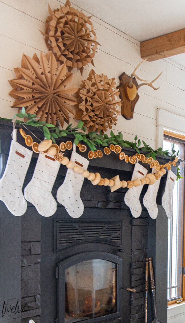 DIY Paper Snowflake Mantel - love the orange slice garland on this festive Christmas mantel 