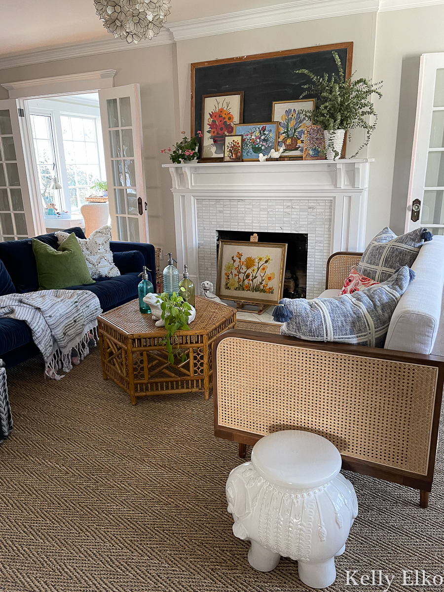 Eclectic boho living room with vintage art and rattan and cane furniture kellyelko.com