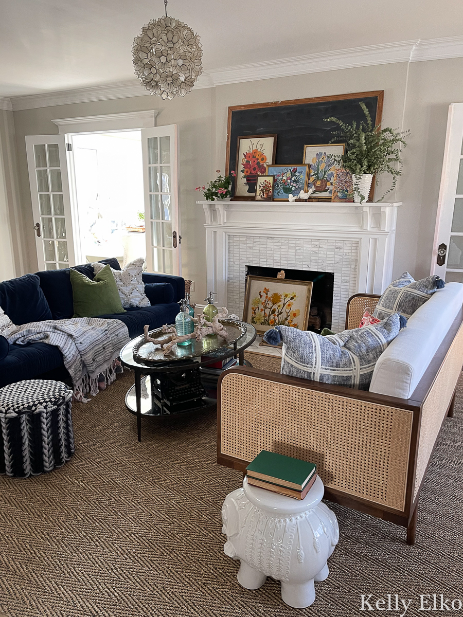 Spring living room with vintage floral art mantel and a beautiful cane sofa kellyelko.com