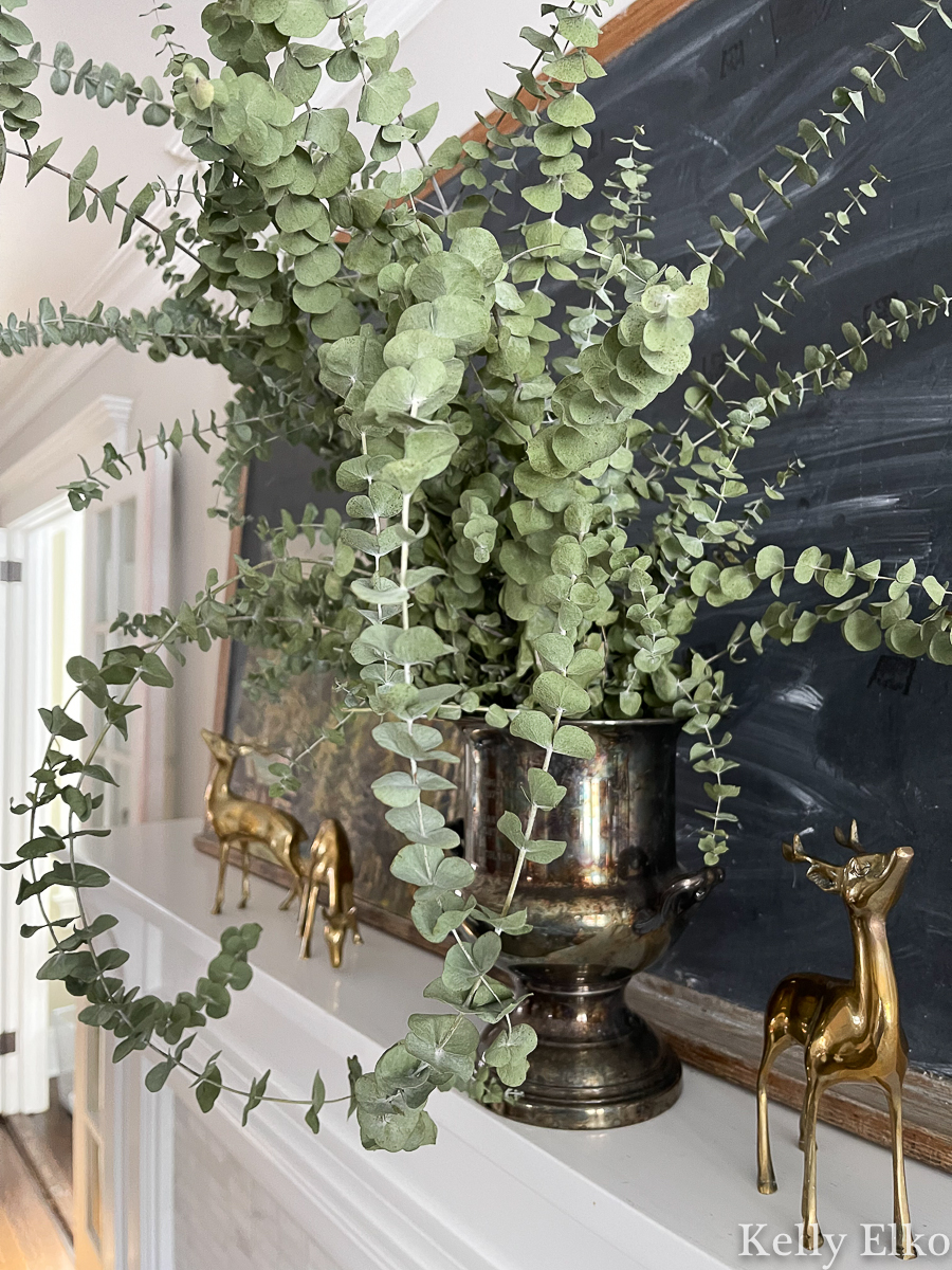 Love this huge bouquet of eucalyptus on this winter mantel with vintage brass deer kellyelko.com