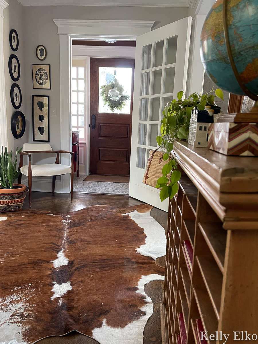 Farmhouse entry with cowhide rug and vintage furniture kellyelko.com