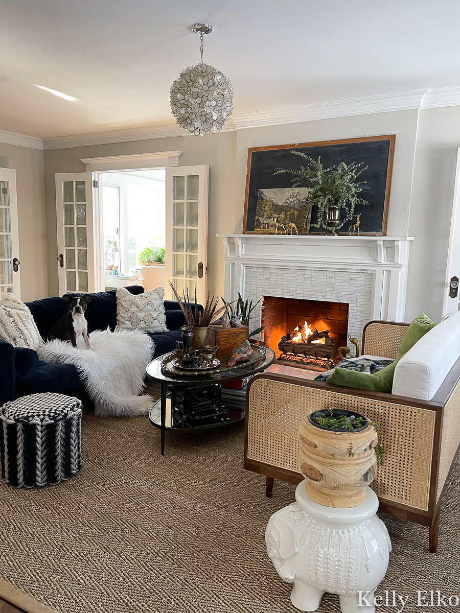 Love the furniture placement in this living room with velvet sofa and cane sofa and a stunning mantel with vintage decor kellyelko.com