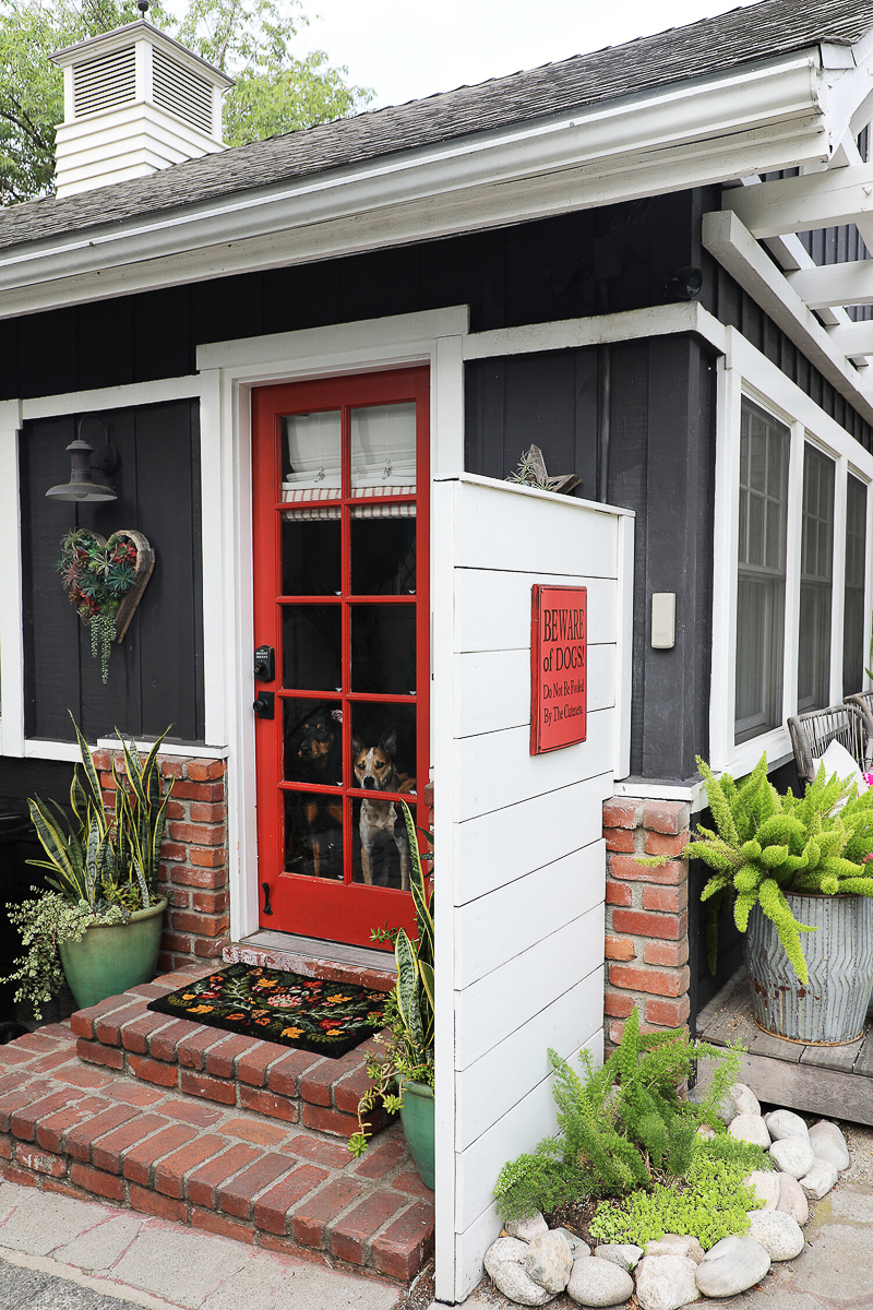 Love this cottage with navy blue paint and red door 
