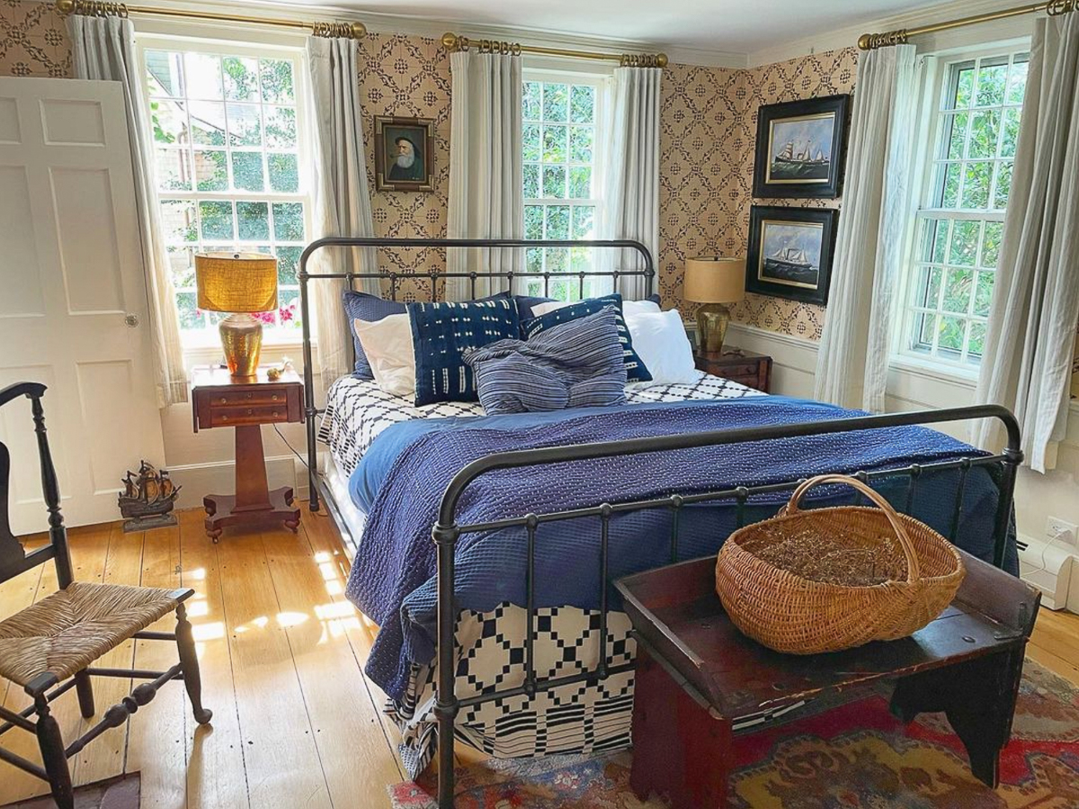 Beautiful bedroom with black iron bed and coastal art 