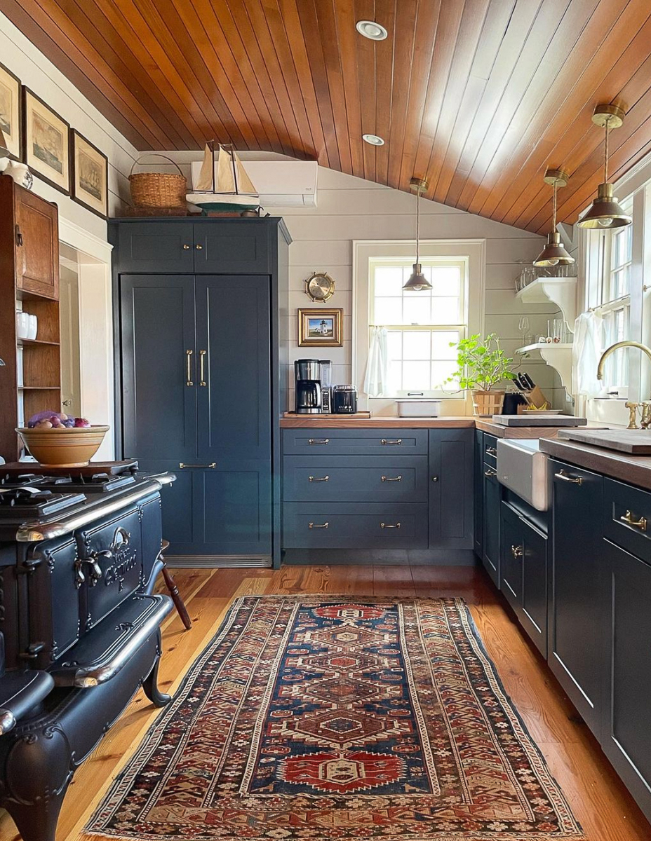 Love this galley kitchen with custom blue cabinets and wood planked ceiling 