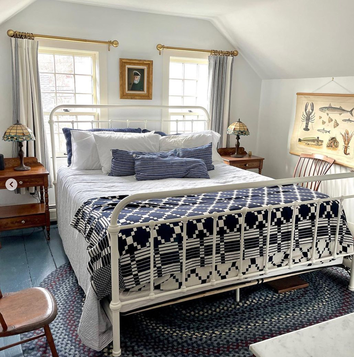 Coastal bedroom with white iron bed and nautical art - love the blue painted wood floors 