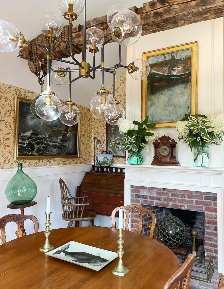 Stunning dining room with modern glass and brass chandelier and antique furniture and fireplace 