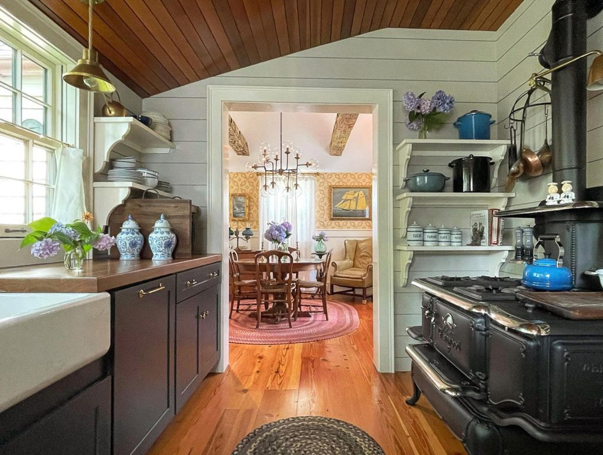 Charming kitchen with blue cabinets and old wood stove converted to gas 