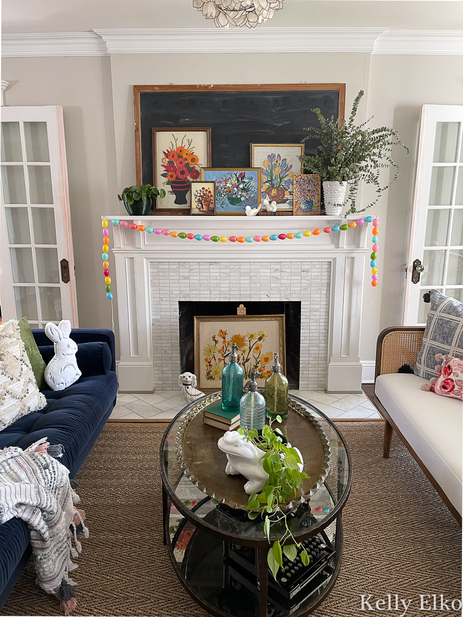 Love the touches of spring in this living room and the colorful egg garland and vintage art kellyelko.com