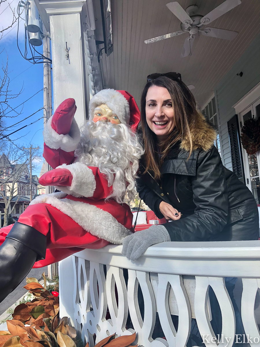 Kelly Elko and her BFF Santa pose on the porch of an old Victorian home kellyelko.com