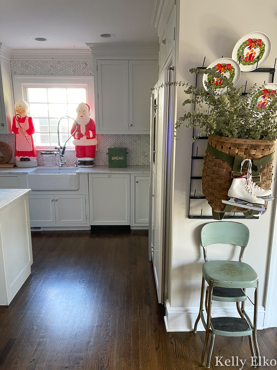 Festive Christmas kitchen with vintage blow molds and a huge old basket tied with ice skates kellyelko.com